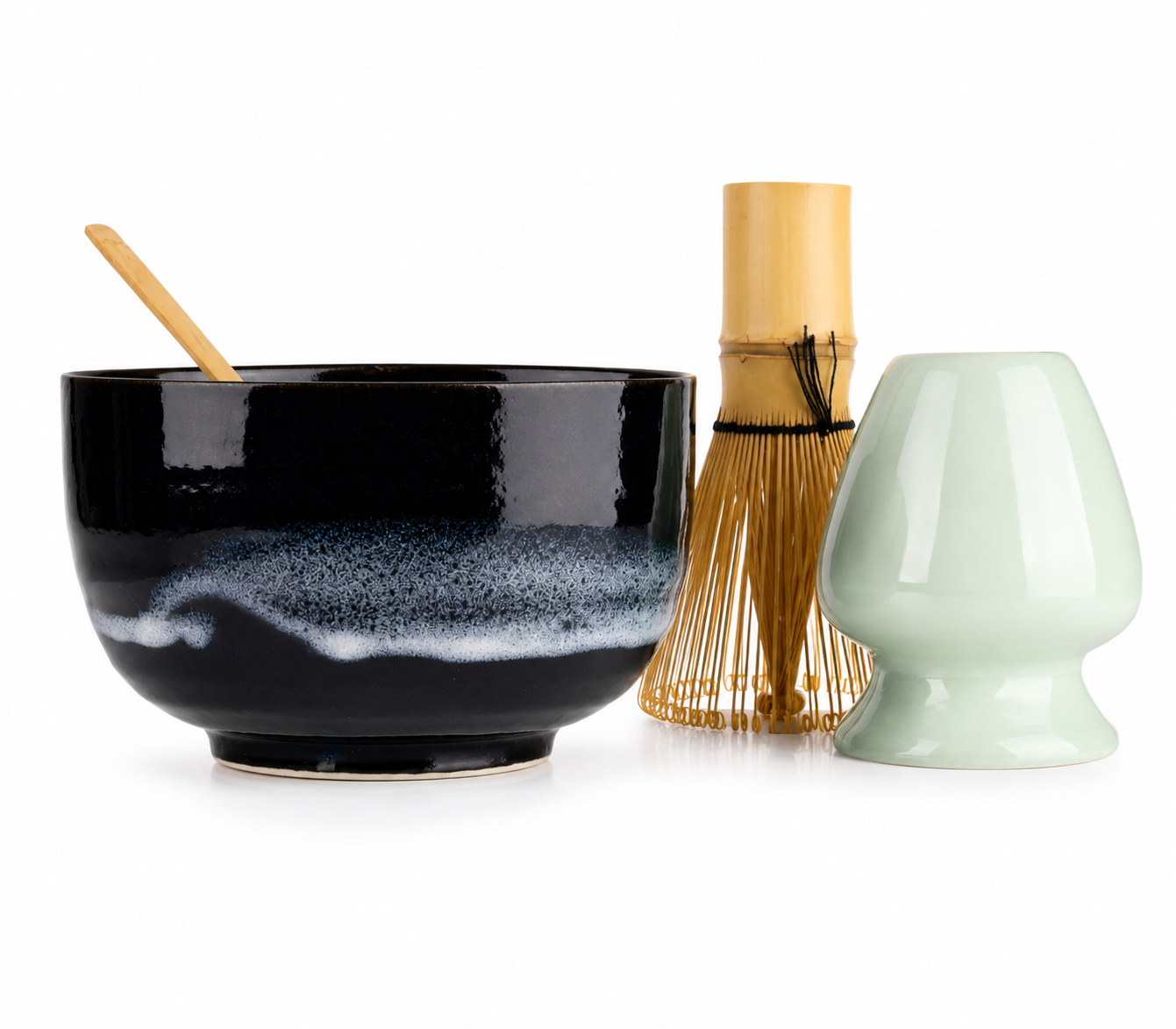 Elegant Japanese ceramic matcha bowl set in indigo blue with traditional floral pattern, including bamboo whisk spoon