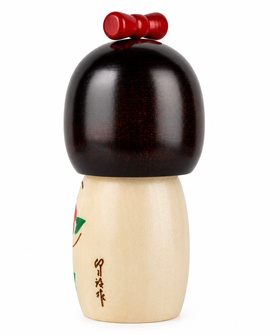     Back view of the Cute Girl with Ribbon Japanese Kokeshi Doll showing the dark wooden hair, red ribbon and artisan signature.