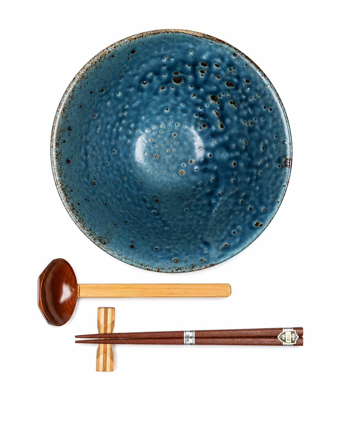 Top view of Blue Wabi Sabi Japanese ramen bowl showing speckled blue glaze interior, with wooden soup spoon, chopsticks and chopstick rest