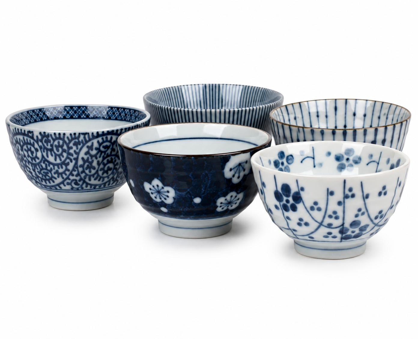 Five Japanese Aizome ceramic rice bowls with blue and white patterns including sakura, stripes, arabesque, and floral designs, shown from above