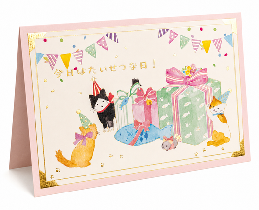 "Front of Lucky Cats Japanese birthday card showing three cats in party hats with colourful gift boxes and bunting, with gold Japanese script 今日はたいせつな日！meaning today is your special day, pink card with gold foil border"