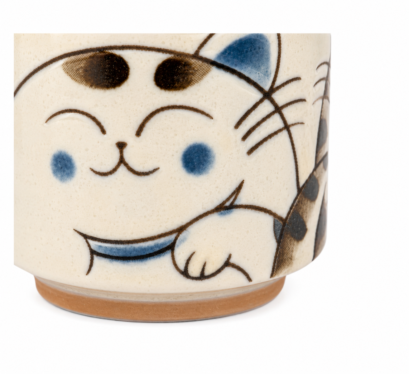 Three Blue Cats Japanese Tea Cup made in Japan – close-up detail of smiling white Maneki-neko cat with blue ears and collar on cream ceramic
