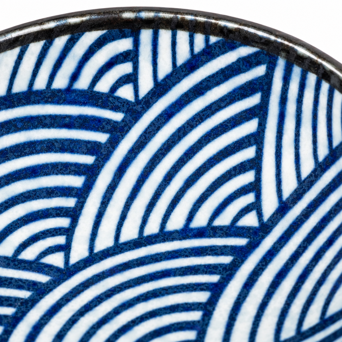 Close-up of Seikaiha wave pattern – blue and white overlapping semicircles on Japanese ceramic dipping bowl